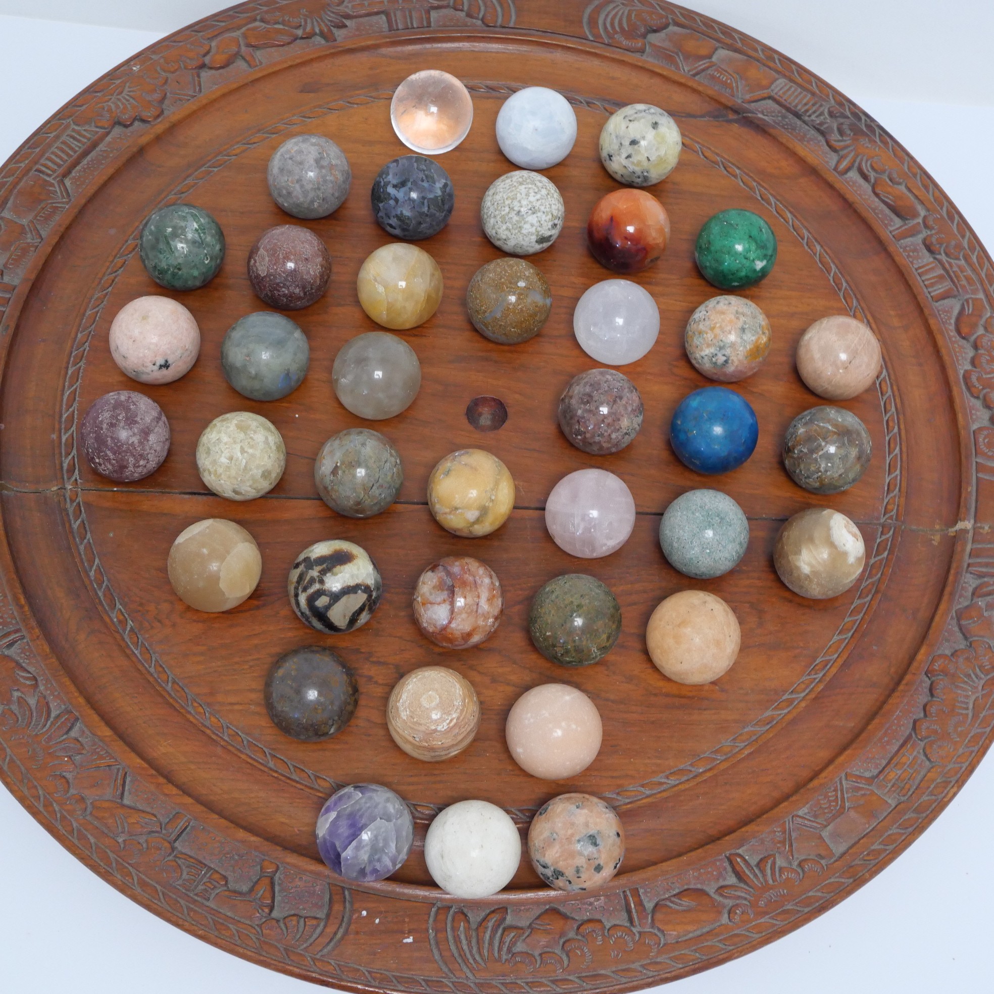 Jeu de solitaire en bois sculpté et billes en pierres naturelles et semi-précieuses Bon état -  reconditionné disponible sur Label Emmaüs