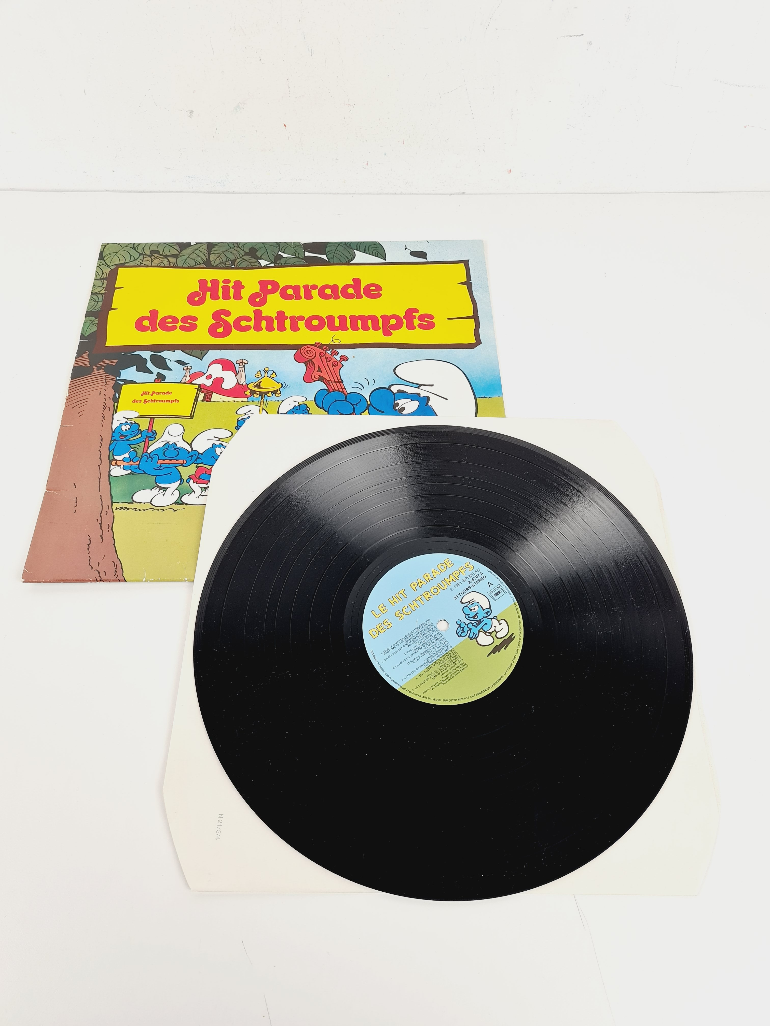 Voir photo 6 de Disque Vinyle Collection 1981 - Hit Parade des Schtroumpfs - Milan - 30x30 cm Disque Vinyle Collection 1981 - Hit Parade des Schtroumpfs - Milan - 30x30 cm Bon état - Vue 6 -